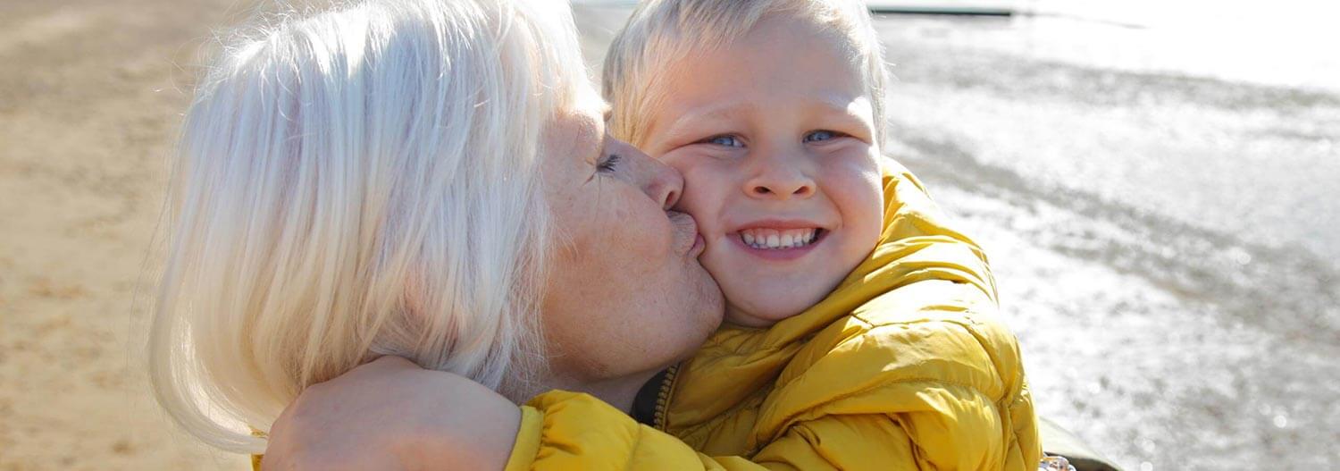 A grandmother kissing and her grandson