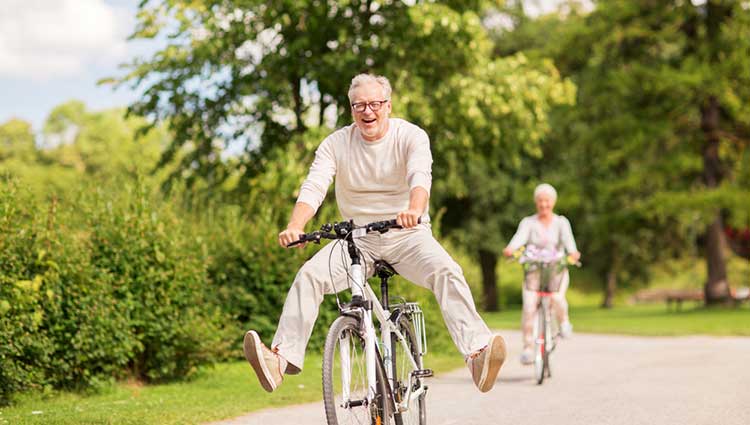 mature man cycling with his feet off the pedals