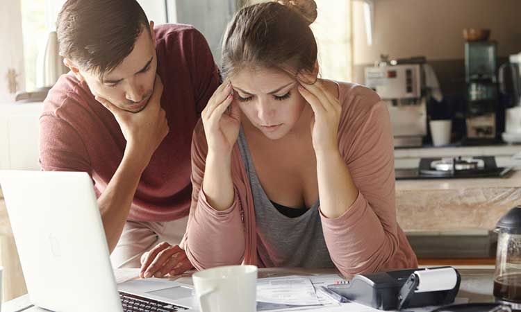 daughter and partner looking at mounting bills