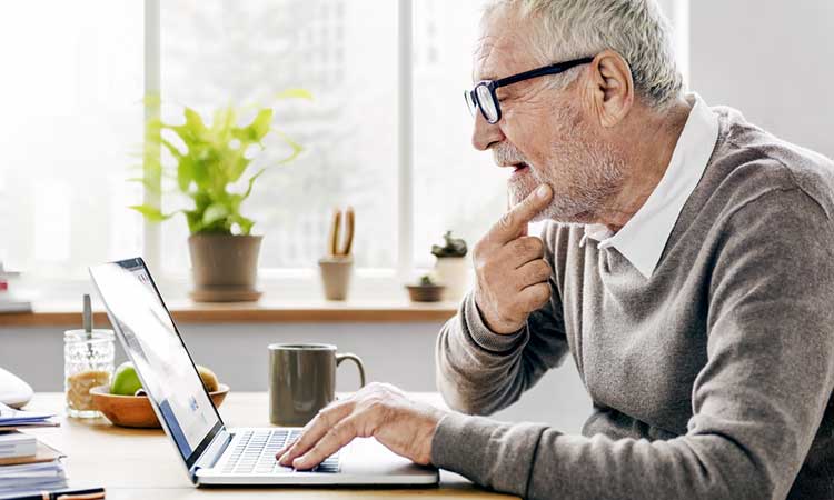 mature man looking at his laptop