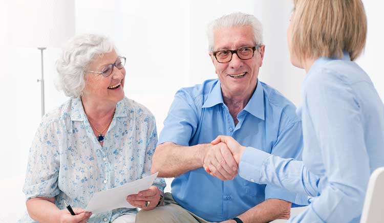 mature couple shaking hands with an independent expert adviser