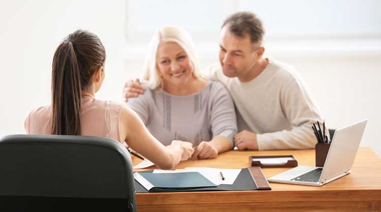 a happy couple talking things over with an equity release adviser