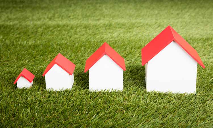 different sized wooden houses sitting on the grass