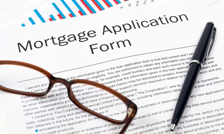 reading glasses and a pen sitting on a mortgage application form