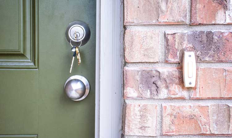 house keys in the lock of a green front door