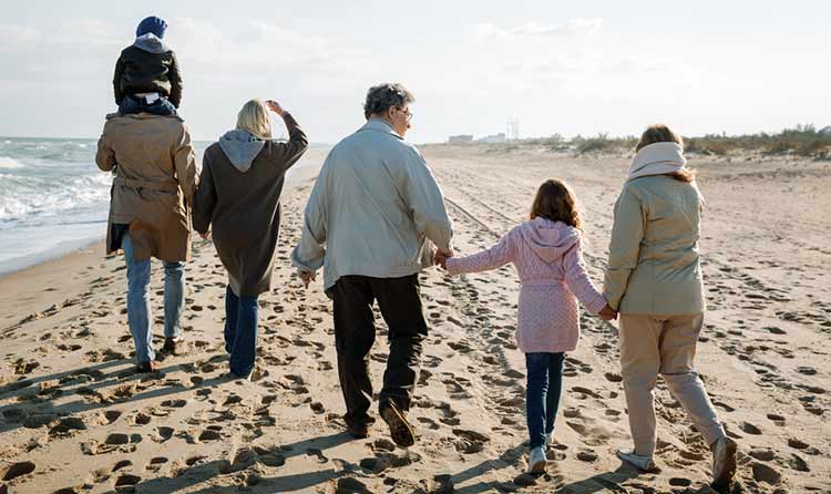 extended family walking along the beach