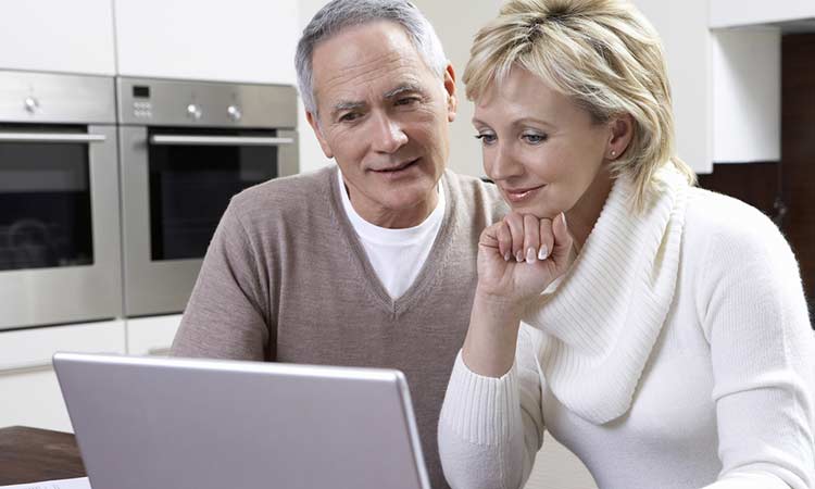 older married couple looking at information on a laptop
