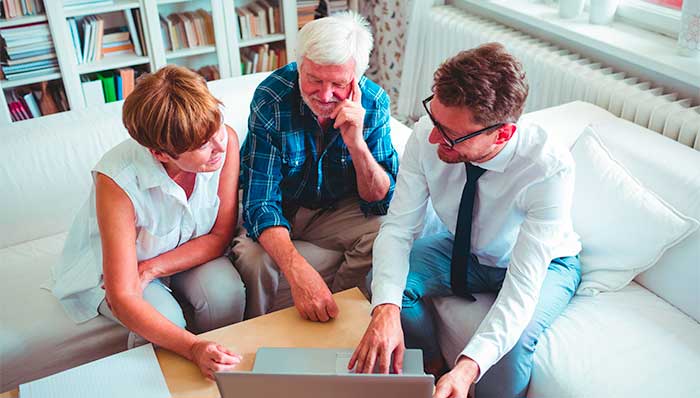 Equity release advice: Mature couple looking at a laptop with an adviser