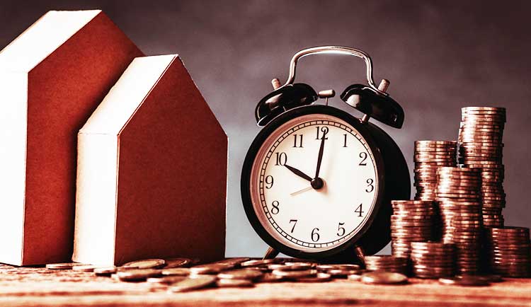 cardboard houses a clock and a pile of coins