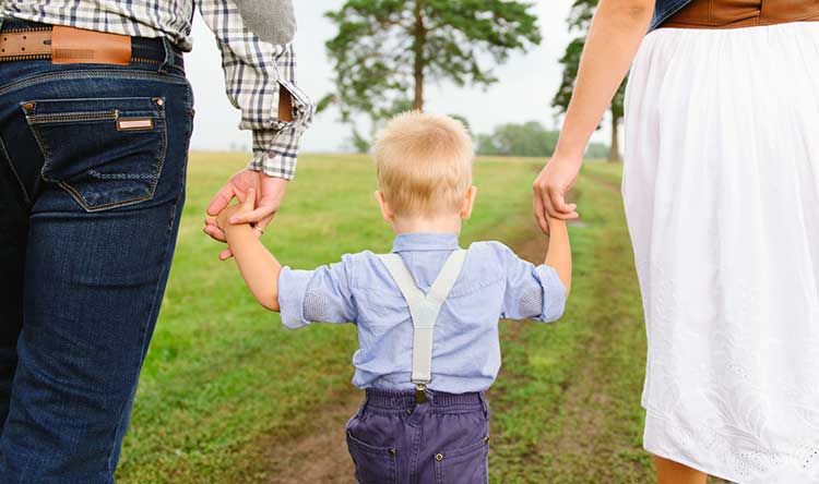 man and a woman holding hands with a young boy