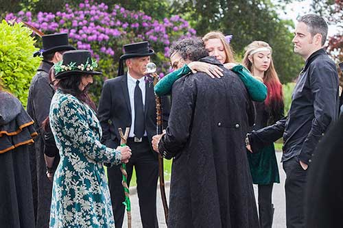 mourners at pagan funeral comforting each other