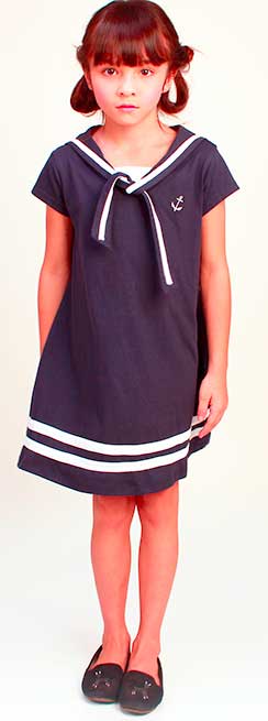 A young girl standing in dark blue sailor dress