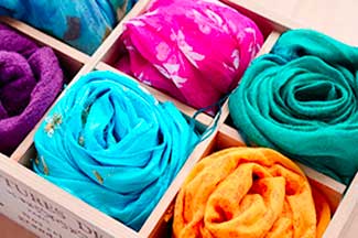 A wooden box of colourful scarfs