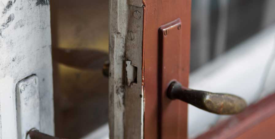 Contents cover: Close up of a door that has been forced