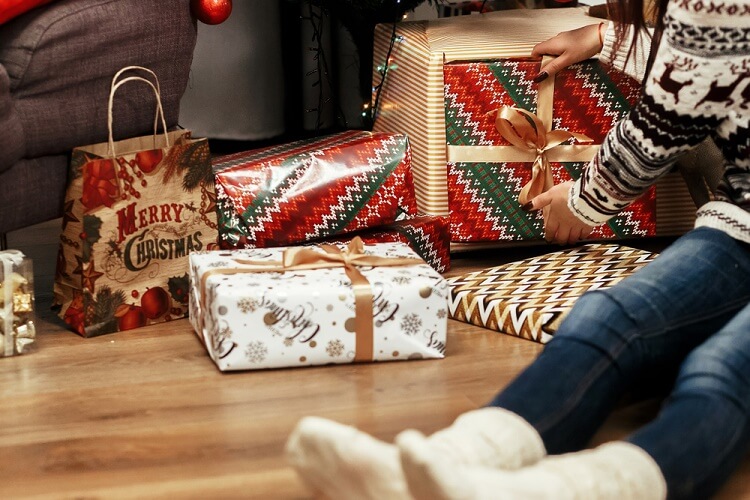 Woman sitting on the floor next to Christmas presents