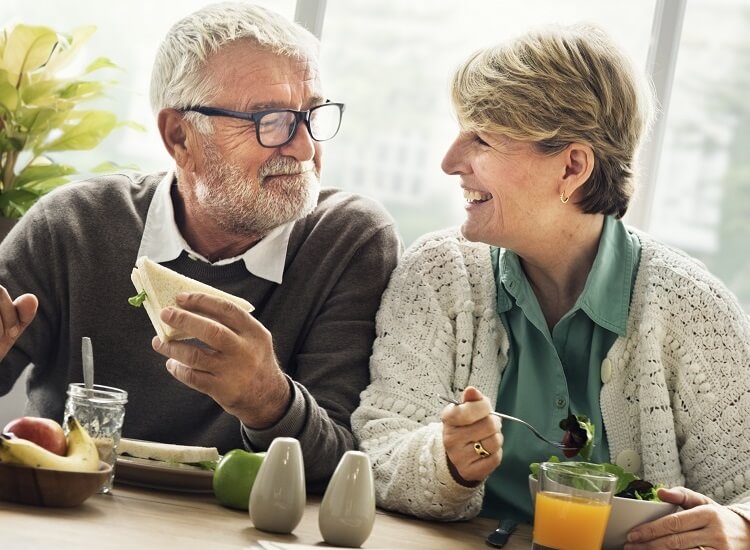 Older couple laughing and enjoying lunch