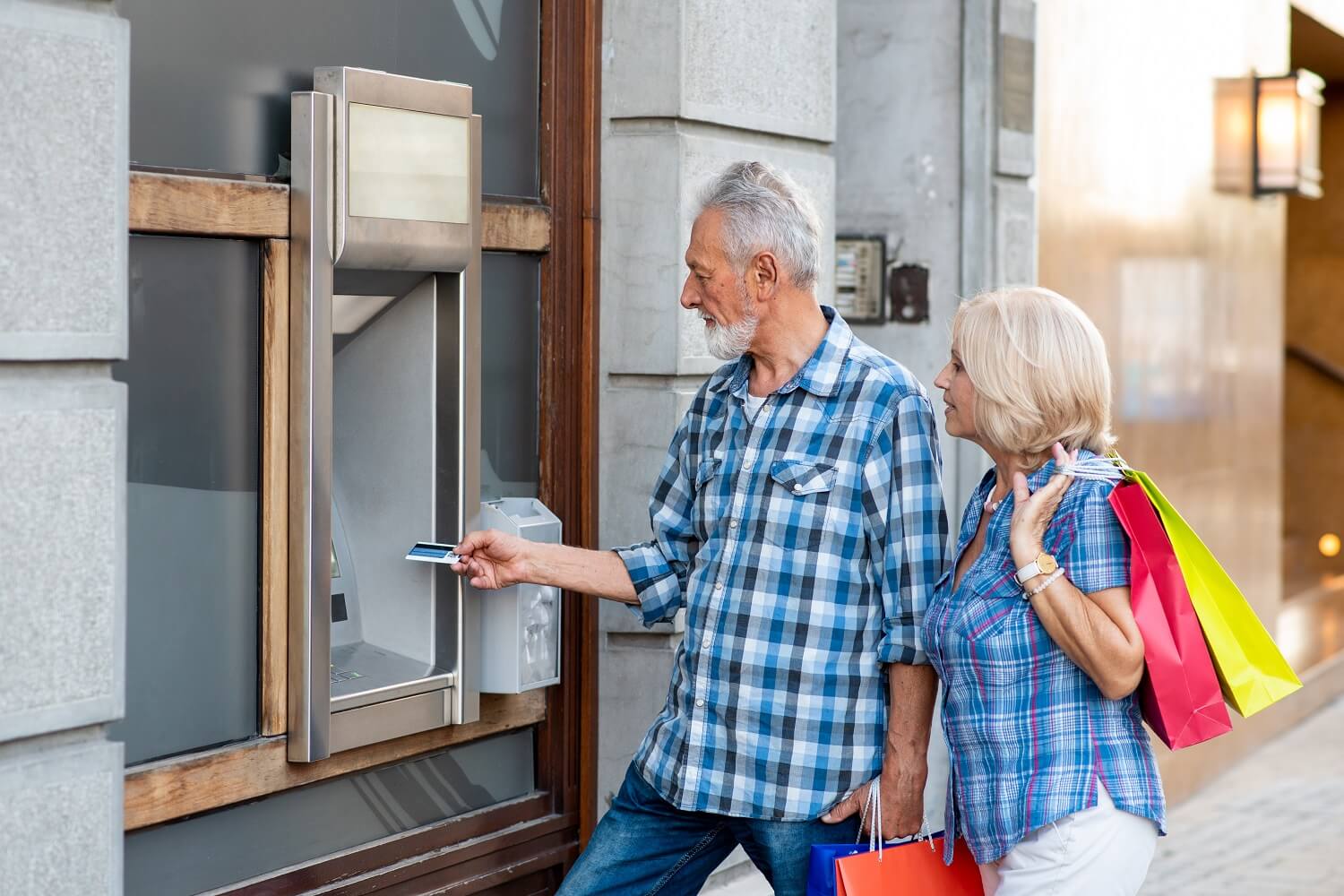 Couple with shopping at a cash machine