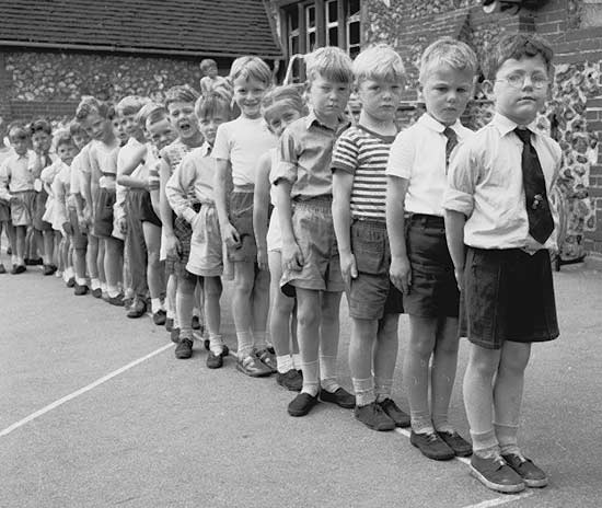 Children standing in a straight line in the playground