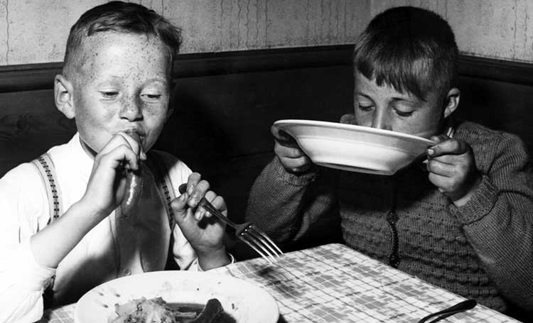 two young boys devouring their dinner