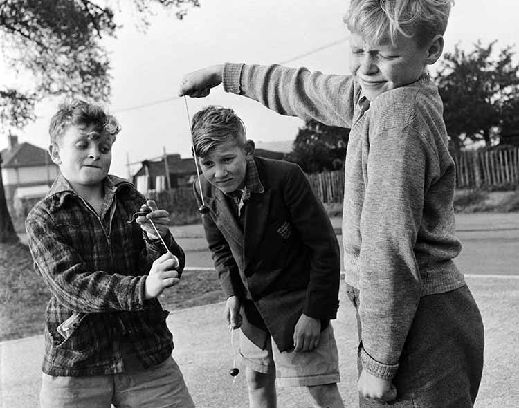 three boys playing conkers