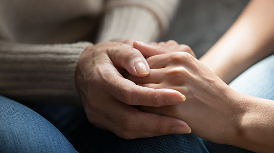 Two pairs of hands holding each other