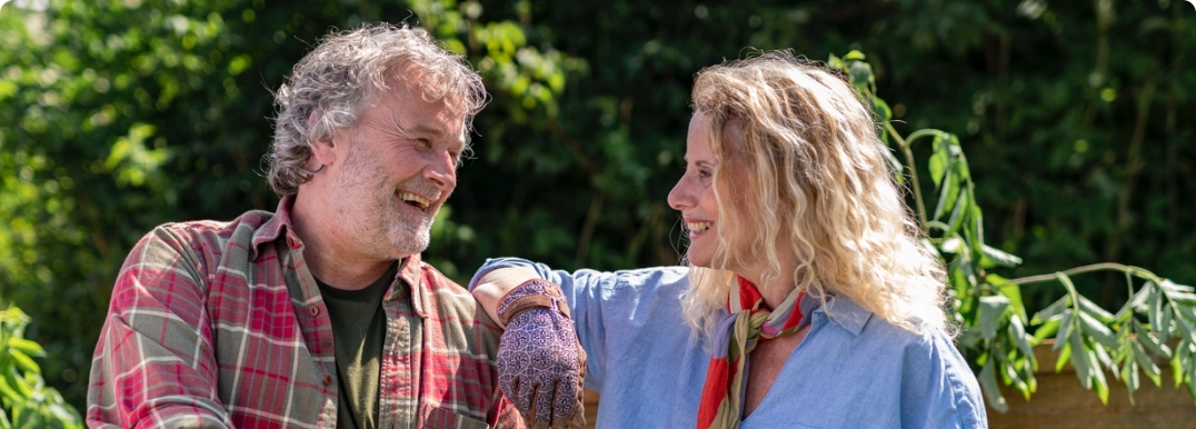 Couple gardening and smiling at each other