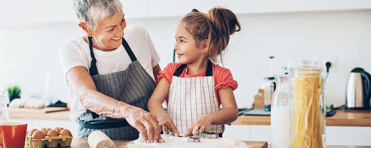 grandparent and grandchildren working in the kitchen