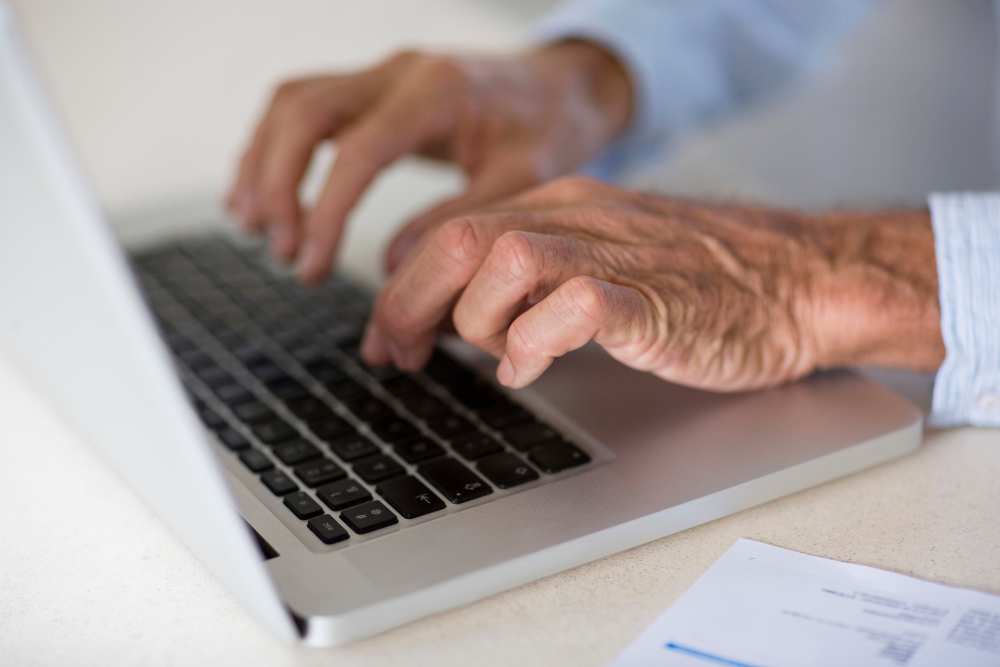 Hands typing on a laptop
