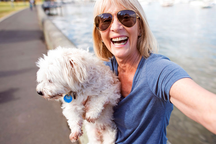 Lady smiling holding her dog.