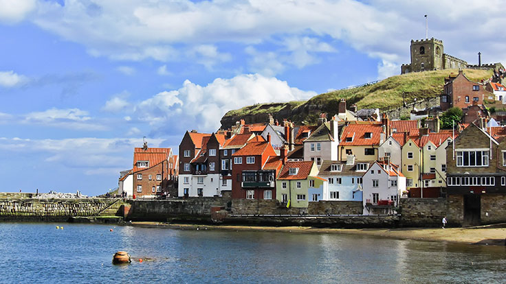 Scenic image of Whitby coastline with houses and church
