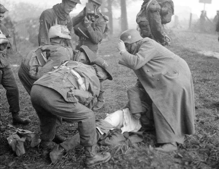 soldiers looking over a wounded soldier