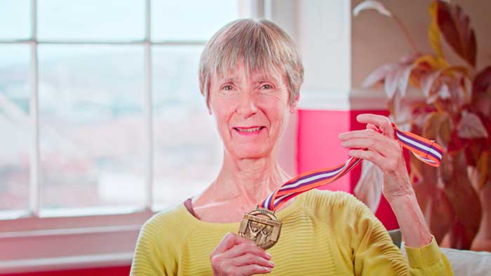Alexandra holding up one of her running medals