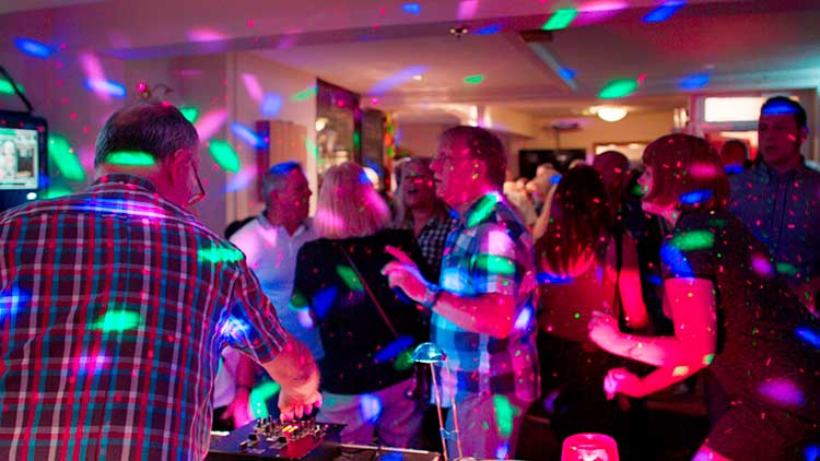 dj bernie playing to a crowd of people dancing