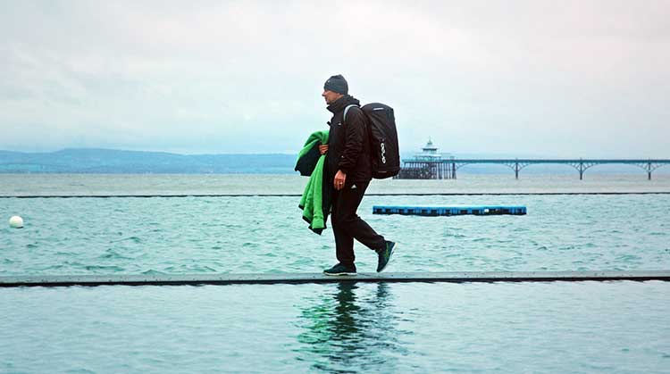 jim walking alongside the sea