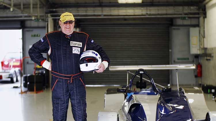 philip standing by a race car holding a helmet