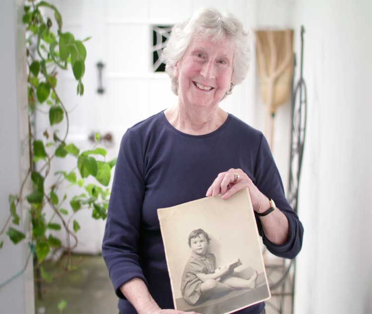 Tessa holding a photograph of her younger herself